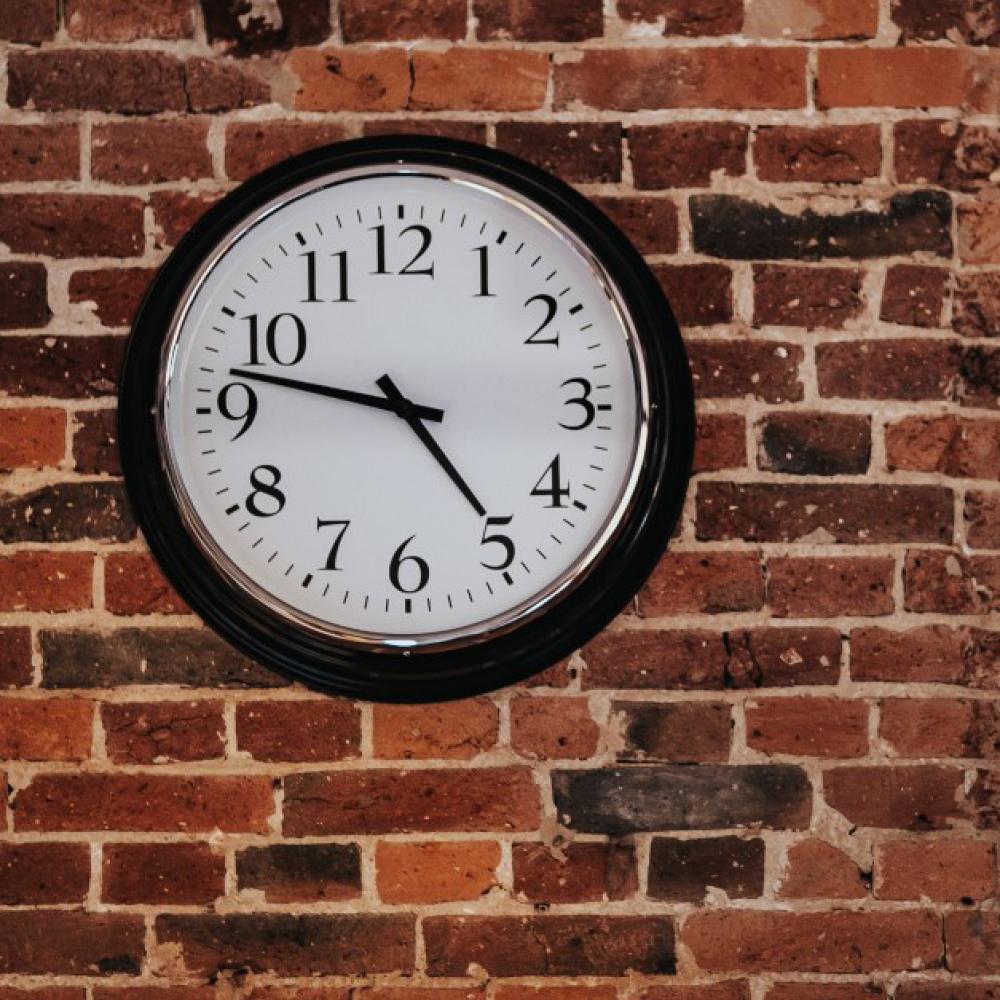 clock hanging on brick wall